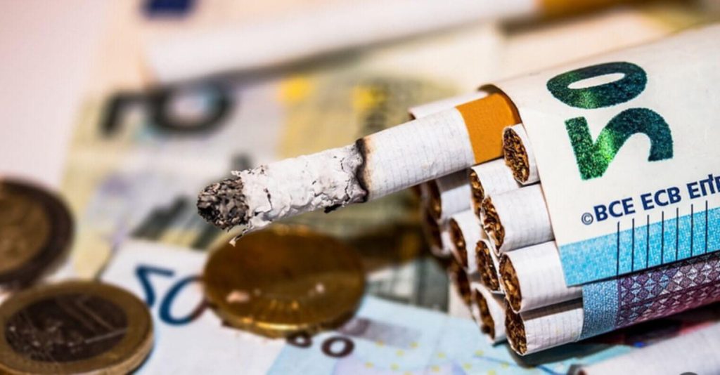 Табачная сигарета и деньги